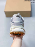 Rear view of the gray sneaker showing the padded heel, pull tab, layered heel structure, and tan outsole.