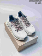 Pair of white and gray On Cloudtilt sneakers displayed on a shoebox, showing the lace-up upper and segmented sole.