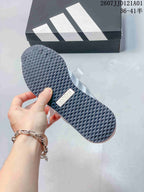 Close-up of the textured dark outsole on a white and gray sneaker