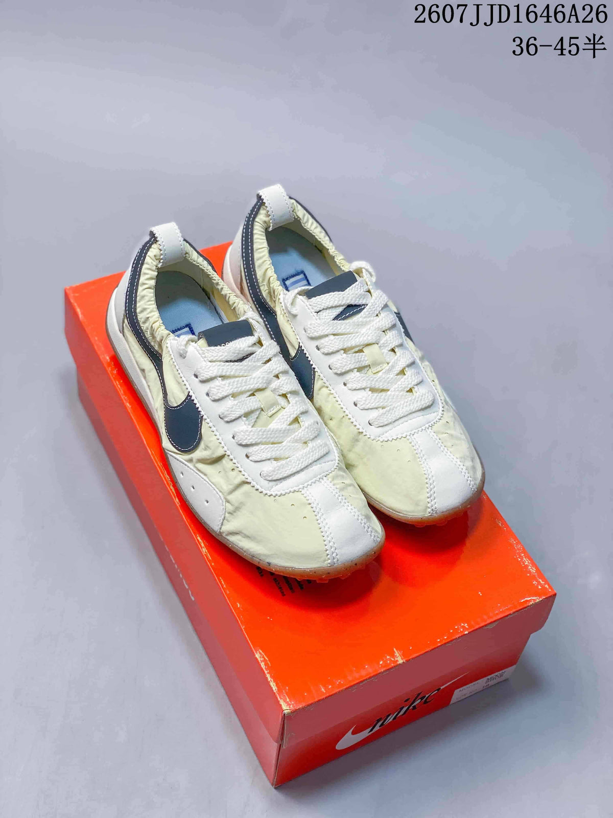 Pair of cream and off-white Nike x Jacquemus low-top sneakers displayed on an orange Nike shoebox.