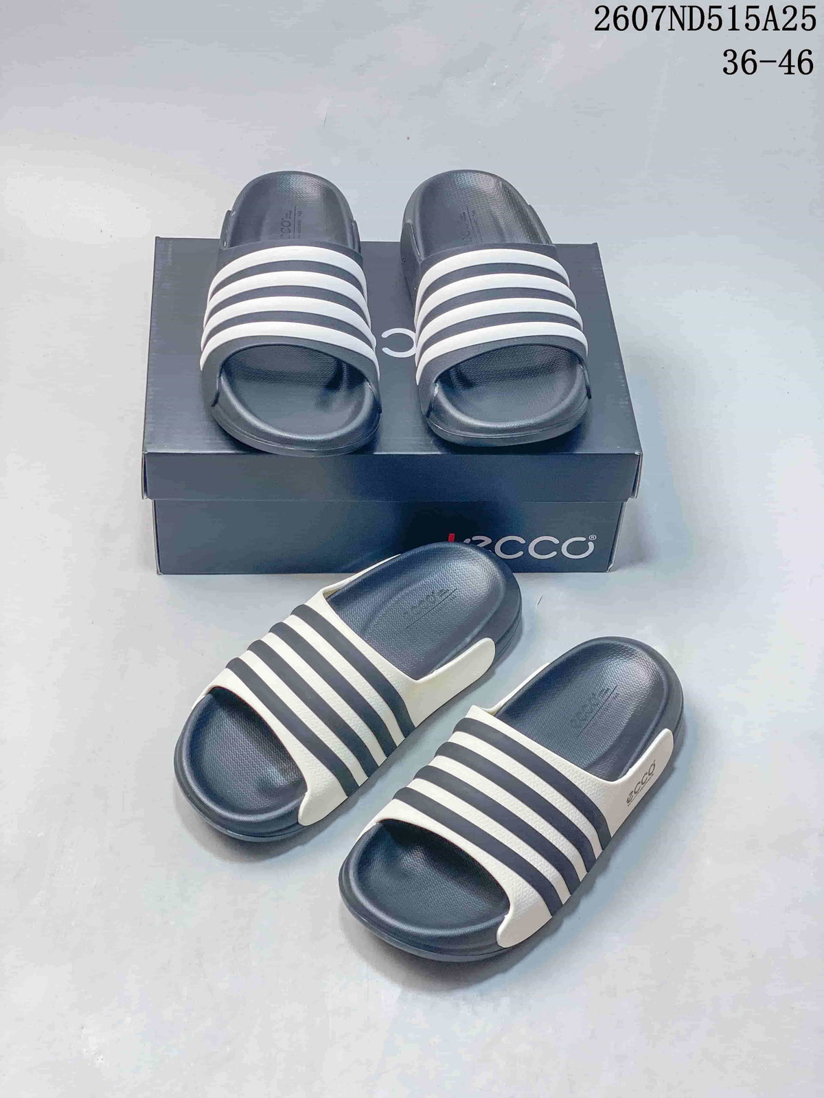 Navy and white ECCO slide sandals arranged in front of and on a branded box, with style code 2607ND515A25 and size range 36–46 visible.