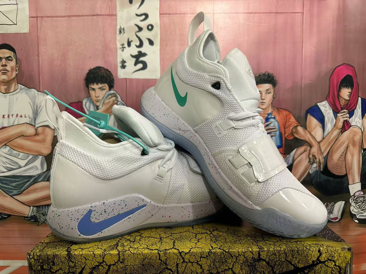 Pair of white Nike PG 6 basketball shoes showing contrasting blue and teal Swooshes and wide straps.