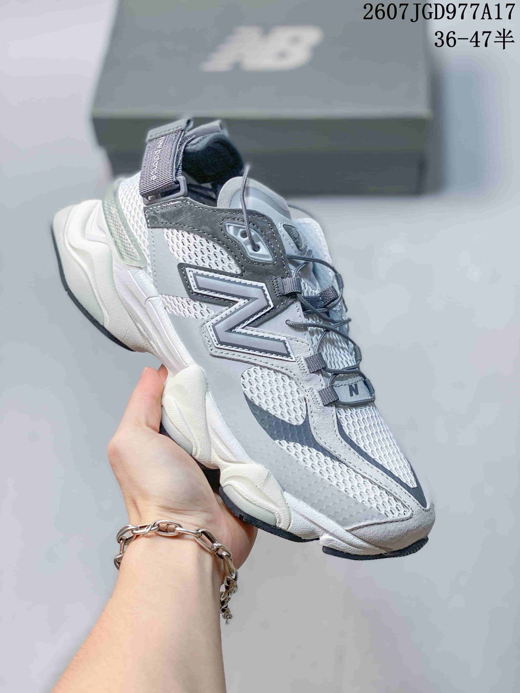 Angled side view of the grey and white New Balance 9060 sneaker with mesh upper and raised sole.