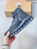 Side profile of a dark gray LOEWE x On high-top sneaker showing the rounded toe, drawstring-style lacing and segmented sole.