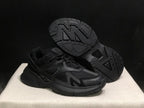 Angled view showing the outsole tread pattern and side profile of the black sneakers.