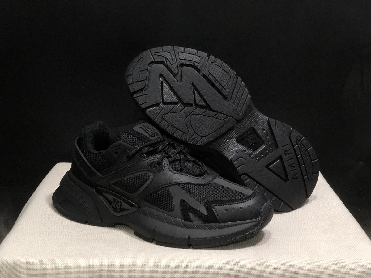 Angled view showing the outsole tread pattern and side profile of the black sneakers.