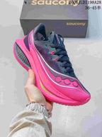 Close side view of a navy and bright pink Saucony running shoe