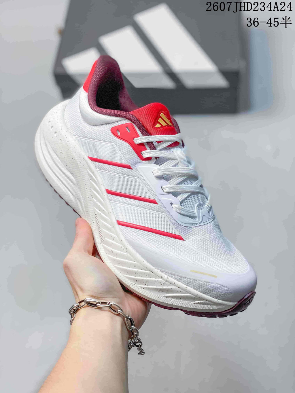 Angled side view highlighting the white low-top design, red accent stripes, red tongue and burgundy outsole.