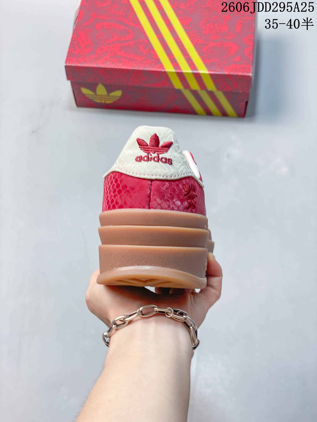 Rear view of the sneaker showing a white heel tab, red upper, and layered gum-colored platform sole.