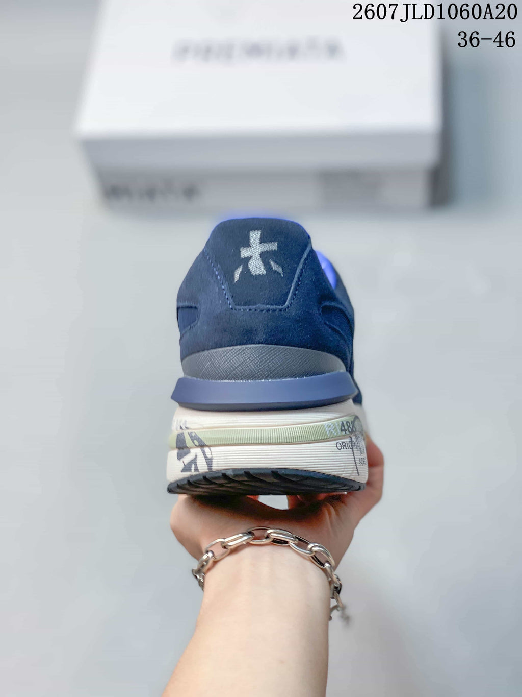 Rear view of the navy trainer showing the padded blue collar, heel branding and layered sole.