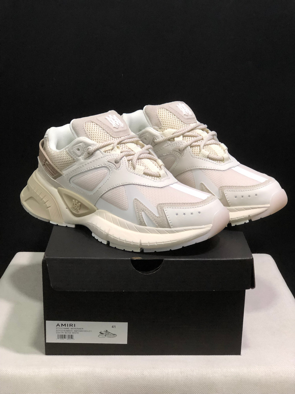Pair of bone white AMIRI MA Runner sneakers displayed on a black shoe box; the box label shows size 41.