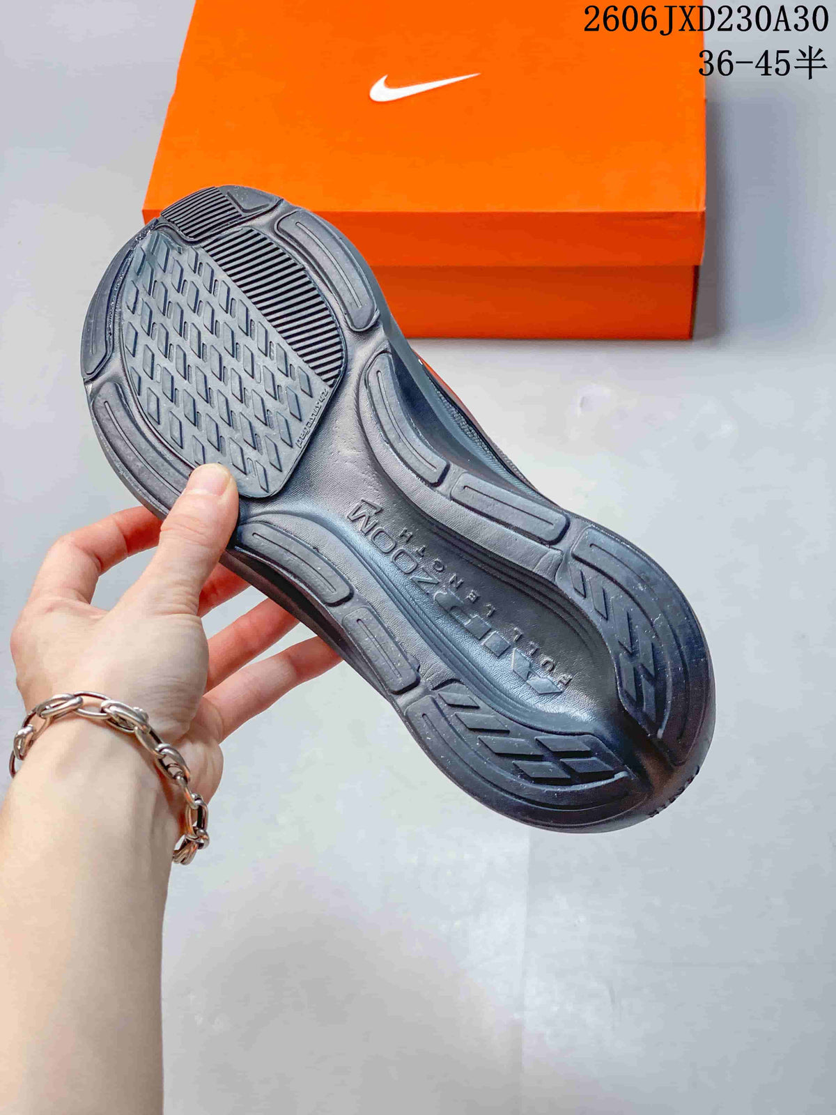 Close view of the patterned outsole on a dark gray running shoe.