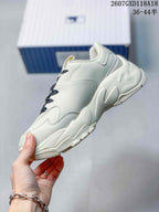 Side view of the white low-top sneaker showing layered panels and a sculpted platform-style sole.