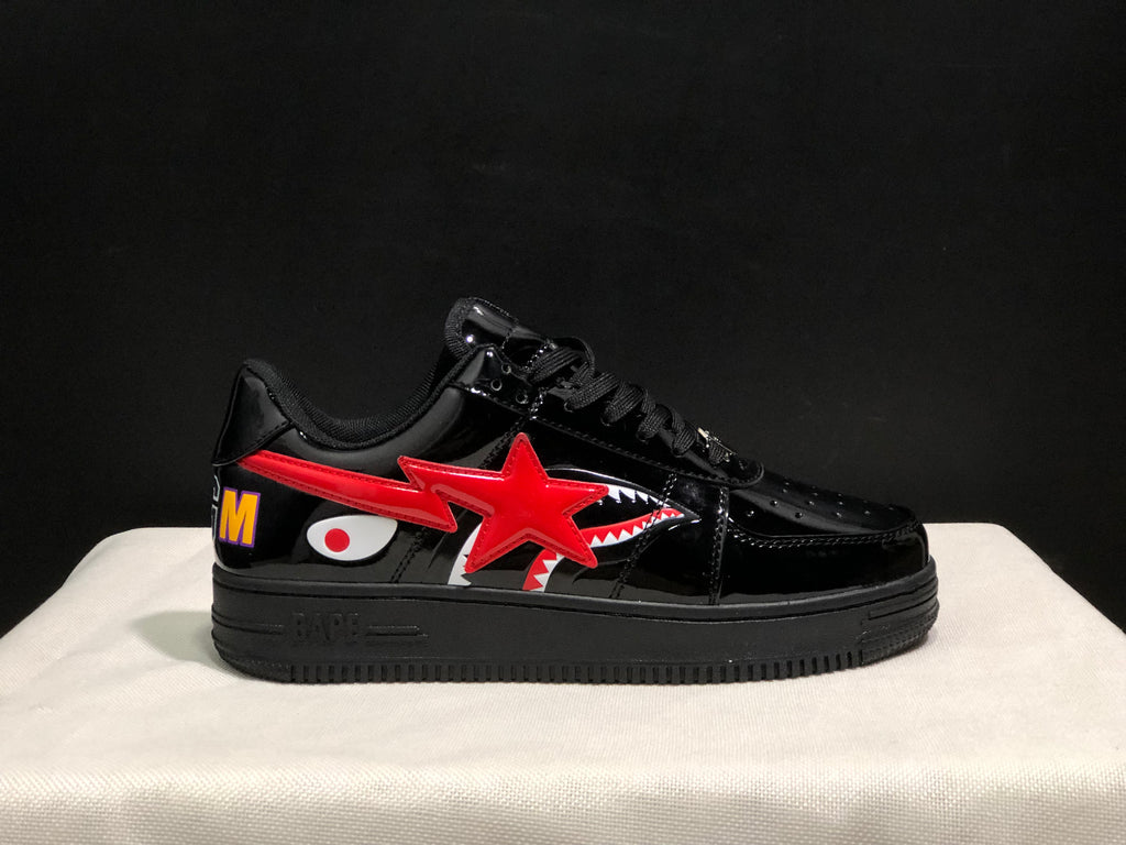 Opposite side profile showing the glossy black upper, red star detail, shark graphic, and multicolor heel letter.