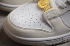 Close-up of the perforated white toe box, layered off-white overlay, and gold-tone clasp.