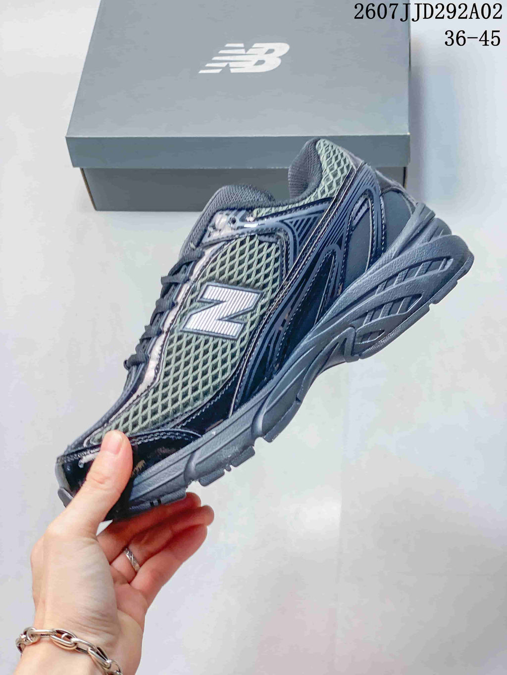 Side profile of the dark gray New Balance 509 sneaker showing the layered upper, mesh panel, large N logo, and sculpted sole.