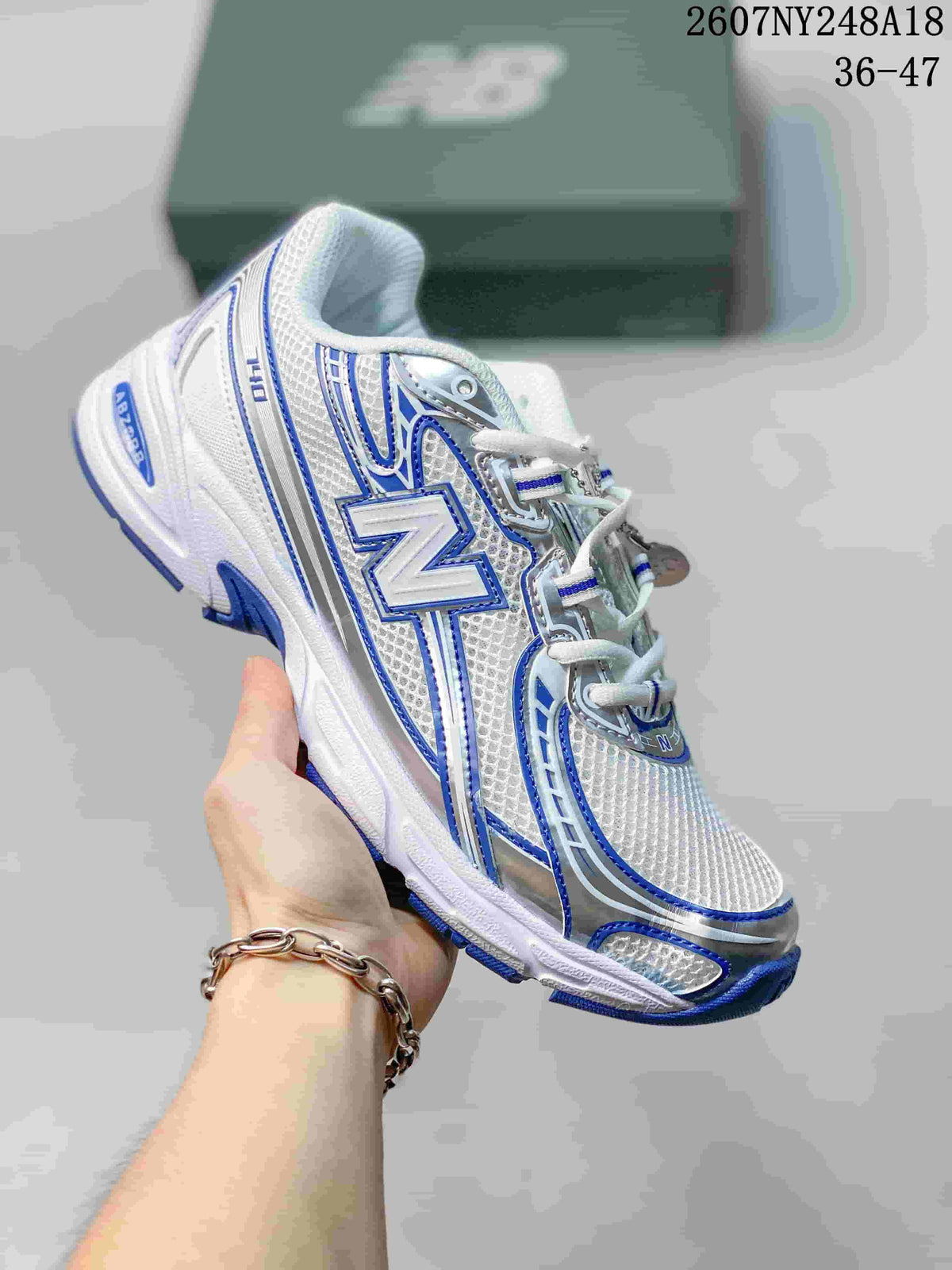 White New Balance 740 sneaker with blue and silver overlays.