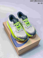Pair of white ASICS GEL-Magic Speed 4 sneakers with neon yellow accents displayed on an ASICS shoe box; image text shows style code 2607JWD245A15 and size range 36-45.