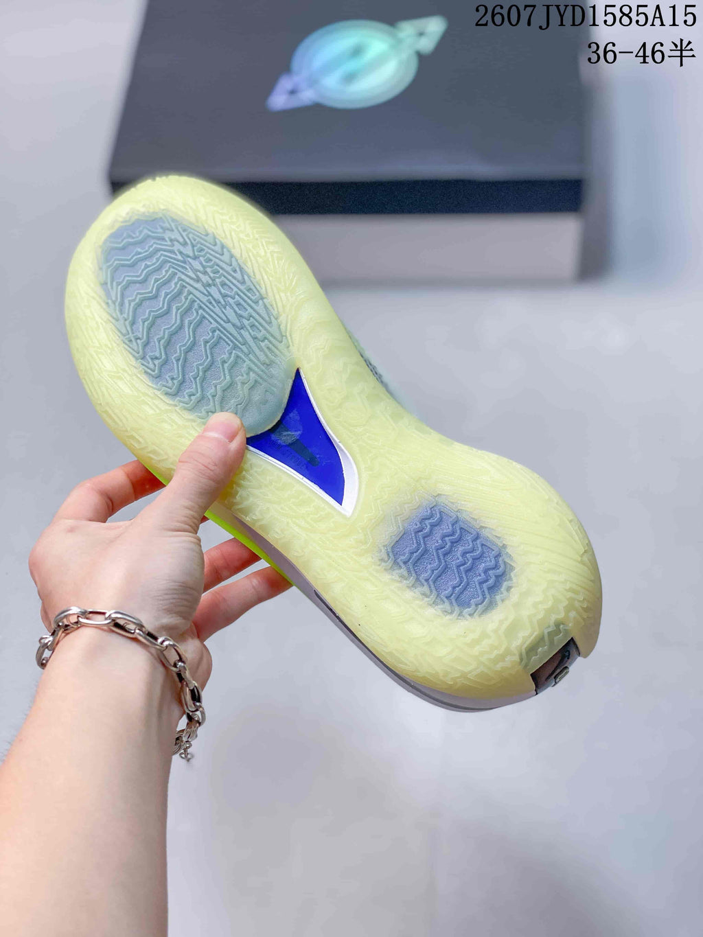 Bottom view of the shoe showing a translucent outsole with patterned traction zones and a blue central insert.