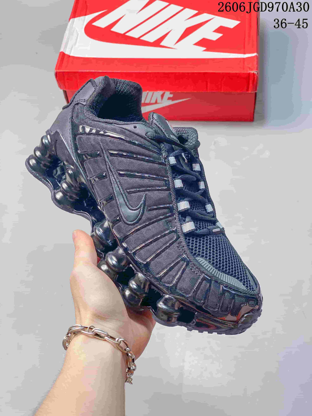 Angled side view showing the mesh toe and segmented sole cushioning of a dark Nike Shox TL sneaker