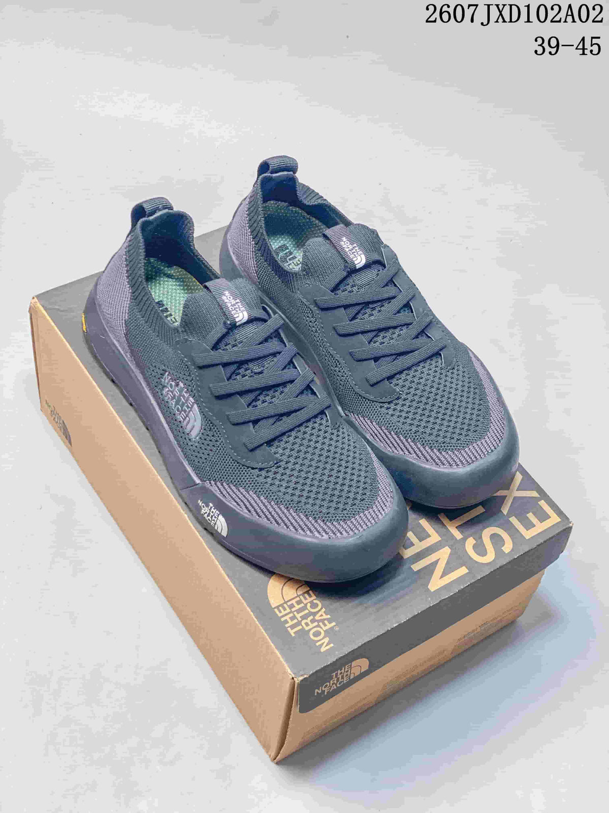 Pair of dark blue-gray The North Face Dune sneakers displayed on a branded shoe box.