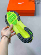 Close view of the neon green and black outsole with segmented traction pattern, with an orange Nike shoe box in the background.