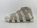 Side view of light neutral Nike Air More Uptempo high-top sneakers with oversized lettering and a segmented outsole