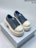 Pair of dark SMFK Future Ripple low-top sneakers with ivory toe caps and chunky platform soles