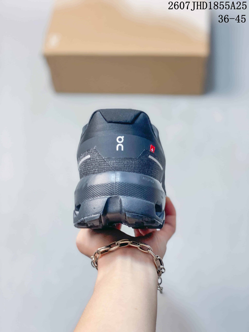 Rear view of the dark gray sneaker showing the padded heel collar, reflective-looking heel detail, and outsole structure.