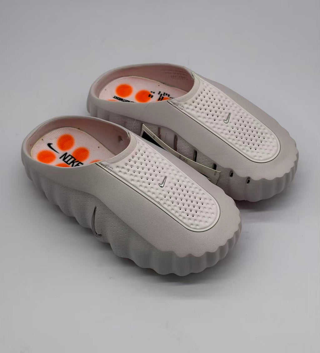 Top view of the pair showing perforated straps, pink footbeds, orange circular graphics, and Nike branding.