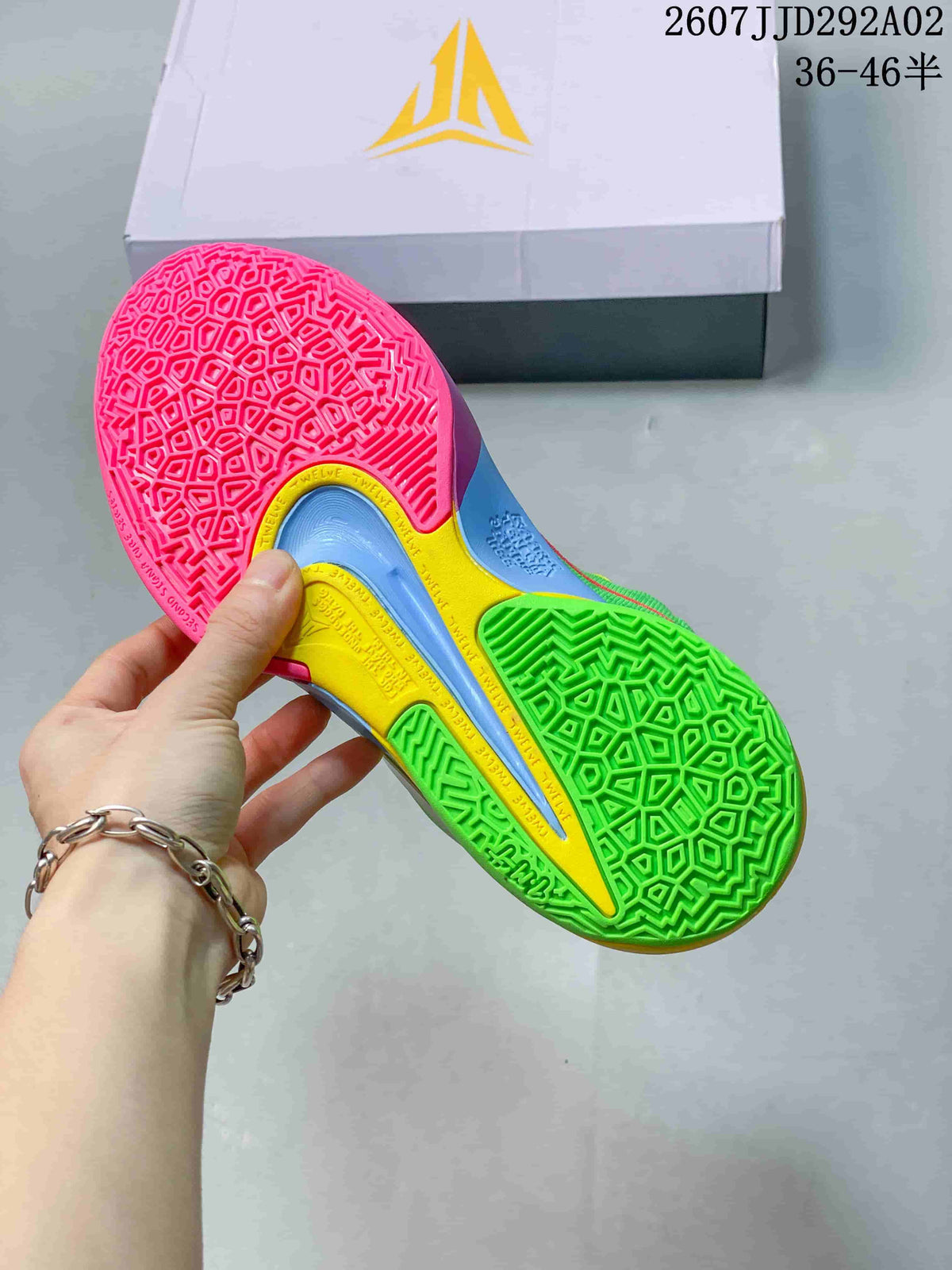 Close view of the colorful basketball shoe outsole showing a geometric traction pattern in pink, green, yellow and blue.