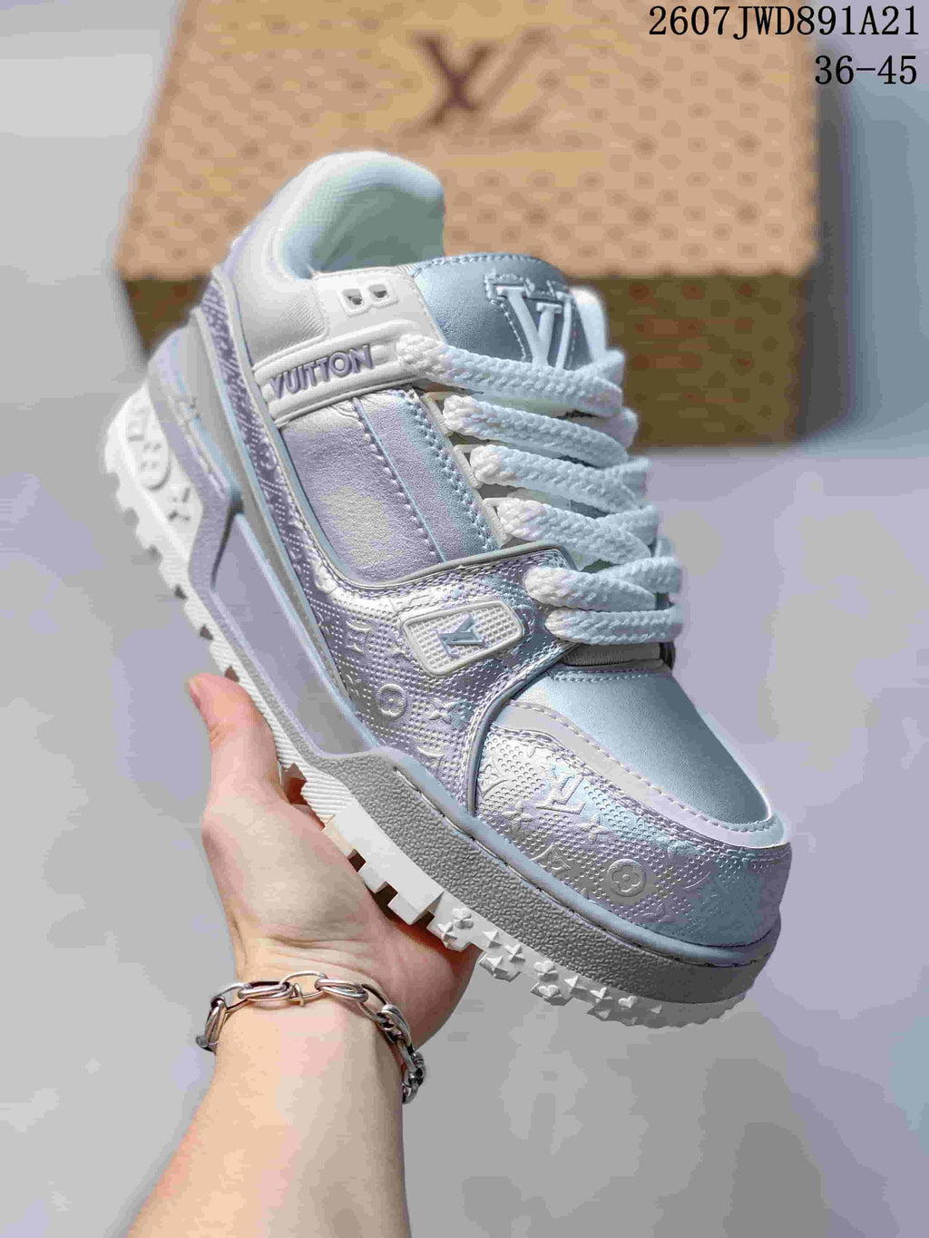 Angled side view of the silver and white sneaker showing the patterned upper, branding, and textured tread.