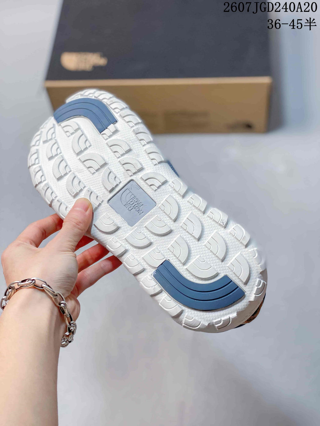 Close-up of the sandal outsole showing a white tread pattern with blue traction sections.