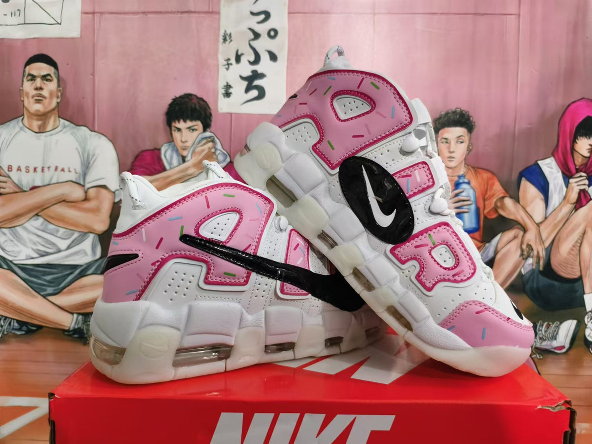 Pair of white and pink Nike sneakers with sprinkle-like accents and visible cushioning units.