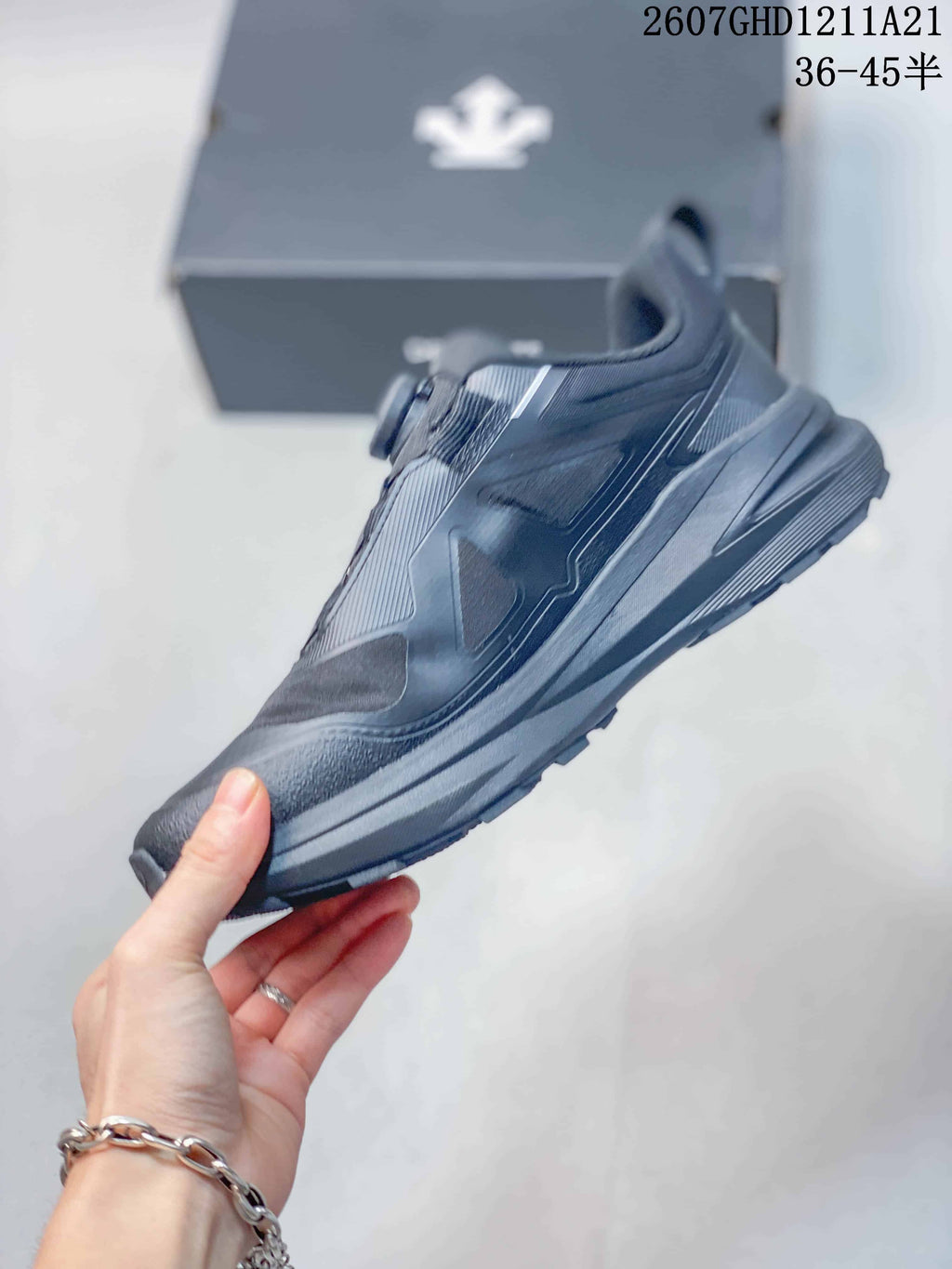 Side profile of the black low-top sneaker showing layered upper panels, a structured midsole, and a lugged outsole.