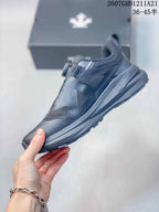 Side profile of the black low-top sneaker showing layered upper panels, a structured midsole, and a lugged outsole.