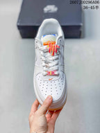 Top view showing the perforated toe box, white laces, orange and yellow tongue details, and decorative lace accessories.