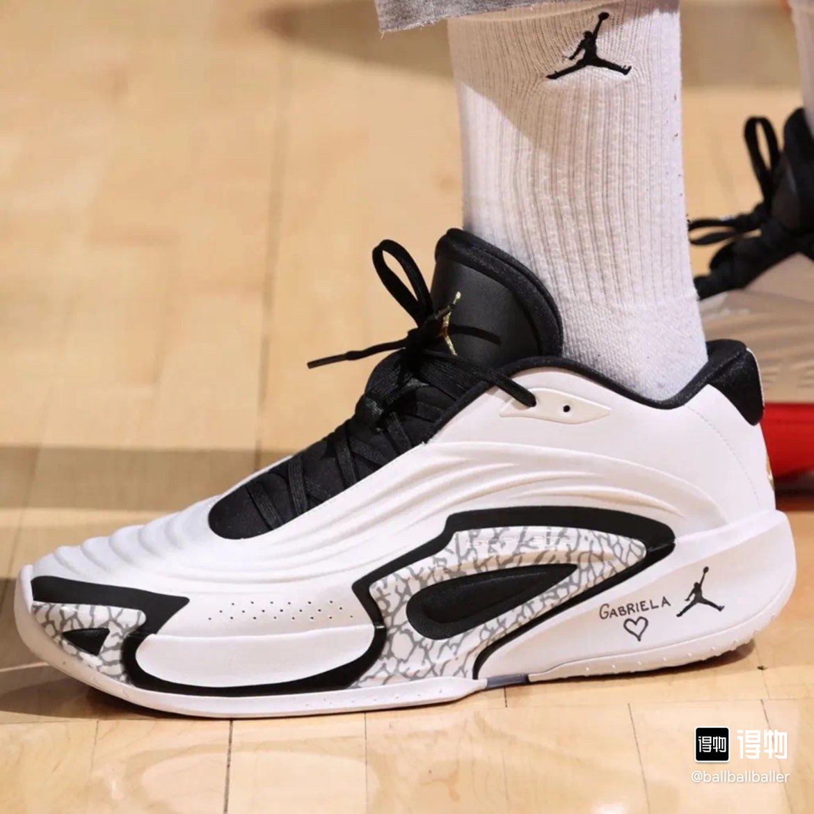 White and black shoe shown on foot with a patterned side panel