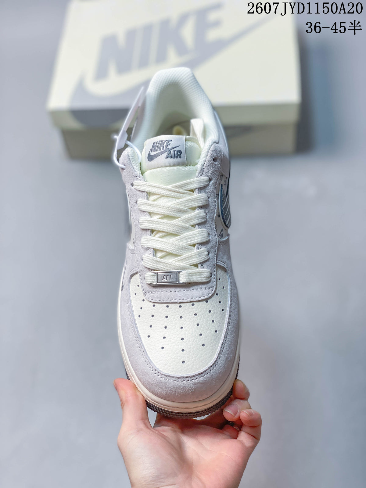 Top-down view of the sneaker showing the perforated white toe box, flat laces, tongue label, and gray overlays.