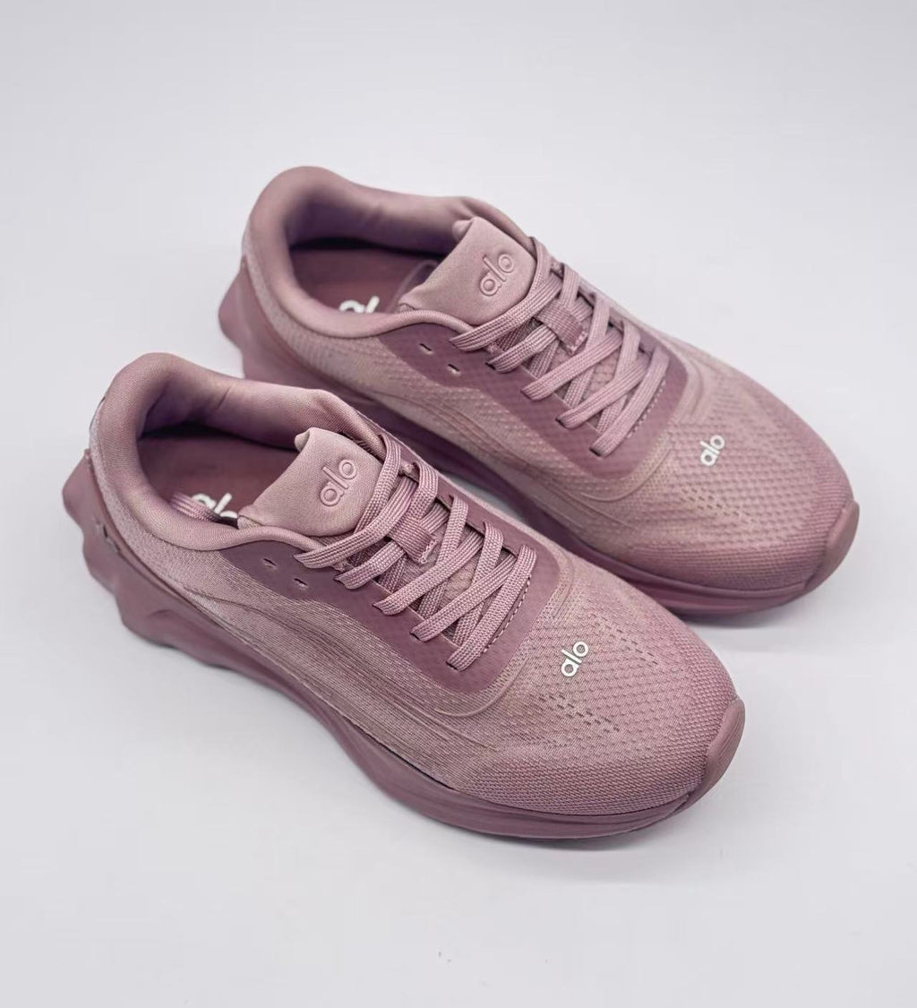 Top three-quarter view of a pair of pink alo lace-up sneakers.