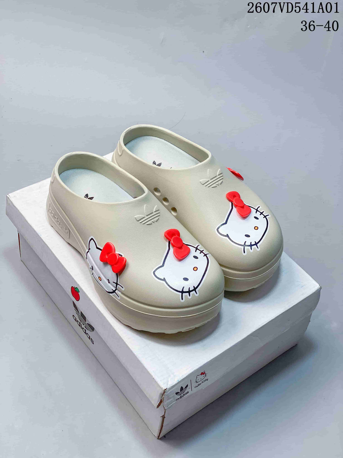 Pair of off-white Hello Kitty platform mule clogs with red bow details.