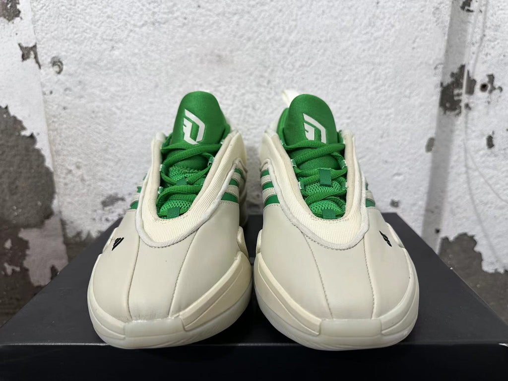 Front view showing green tongues and laces on cream Dame 9 shoes