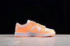 Side profile showing the orange overlays, light gray panels, Nike Swoosh, white midsole, and orange outsole.