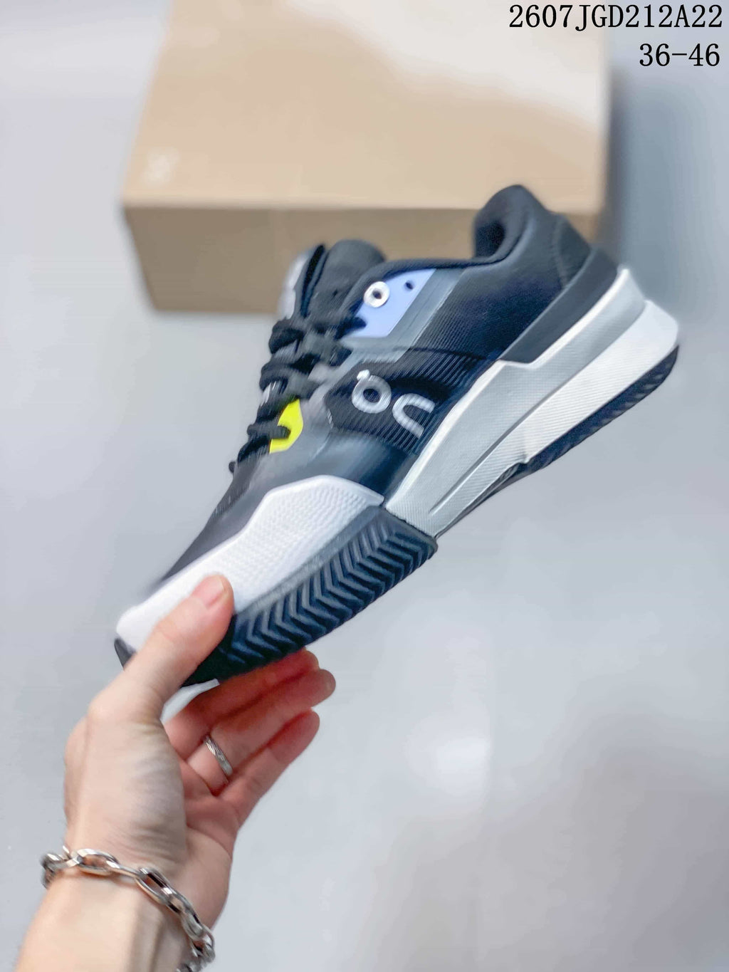 Side view highlighting the black upper, silver-toned side detail, white midsole, and dark outsole.