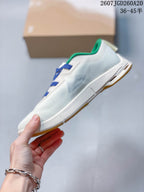 Side profile of the sneaker showing the white upper, layered midsole, and gum-colored outsole sections.