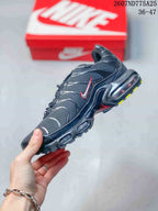 Side view of a black Nike Air Max Plus TN sneaker highlighting the red-accented Swoosh, layered upper panels, and visible air-style midsole structure; overlay text shows code 2607ND775A25 and size range 36–47.