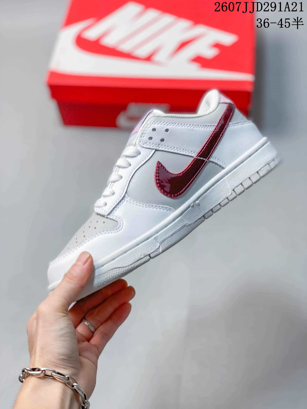 Side profile showing the white upper, red side branding, perforated collar panel, and low-top silhouette.