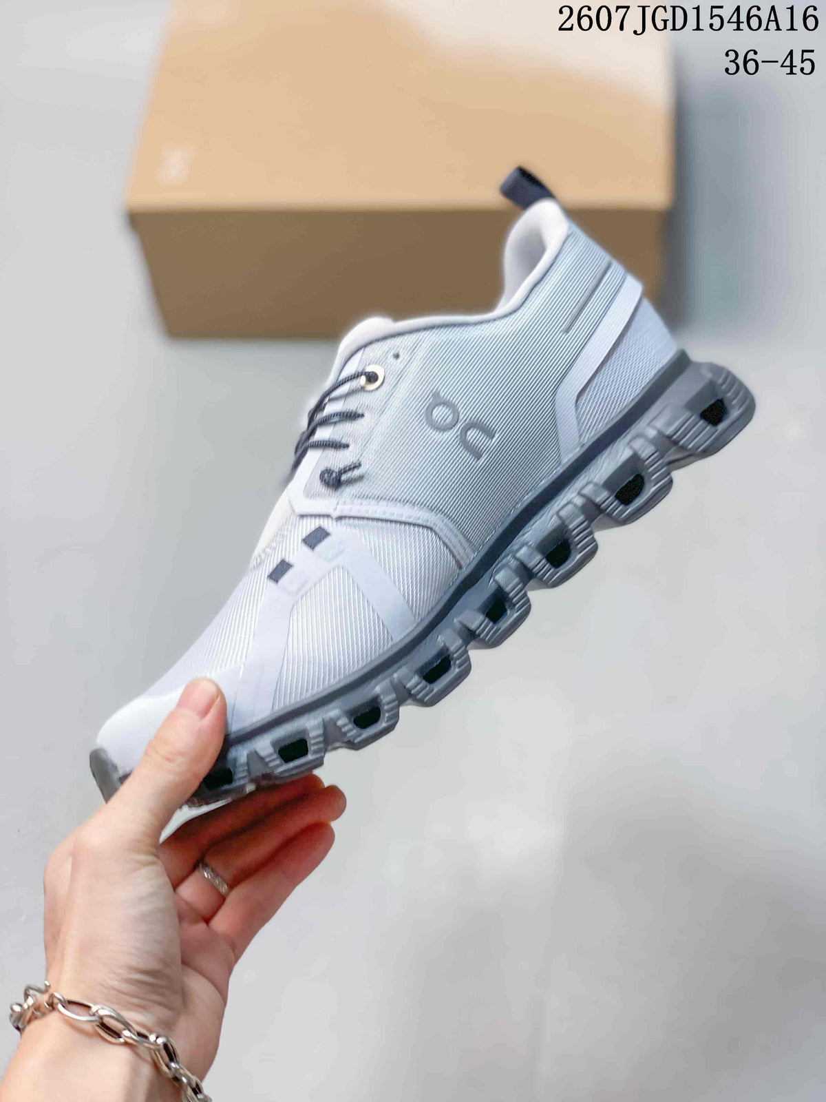 Side profile of the white and gray sneaker showing the patterned upper, ON side branding, lace structure and segmented outsole.