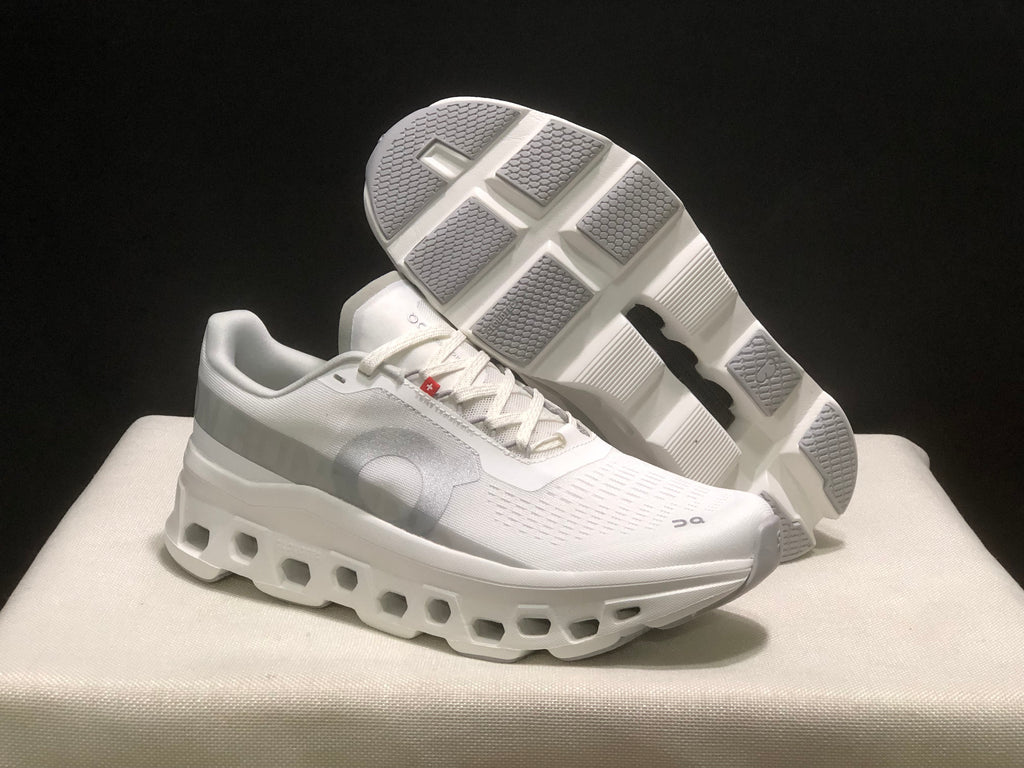 Three-quarter view with one sneaker lifted to reveal the segmented outsole.