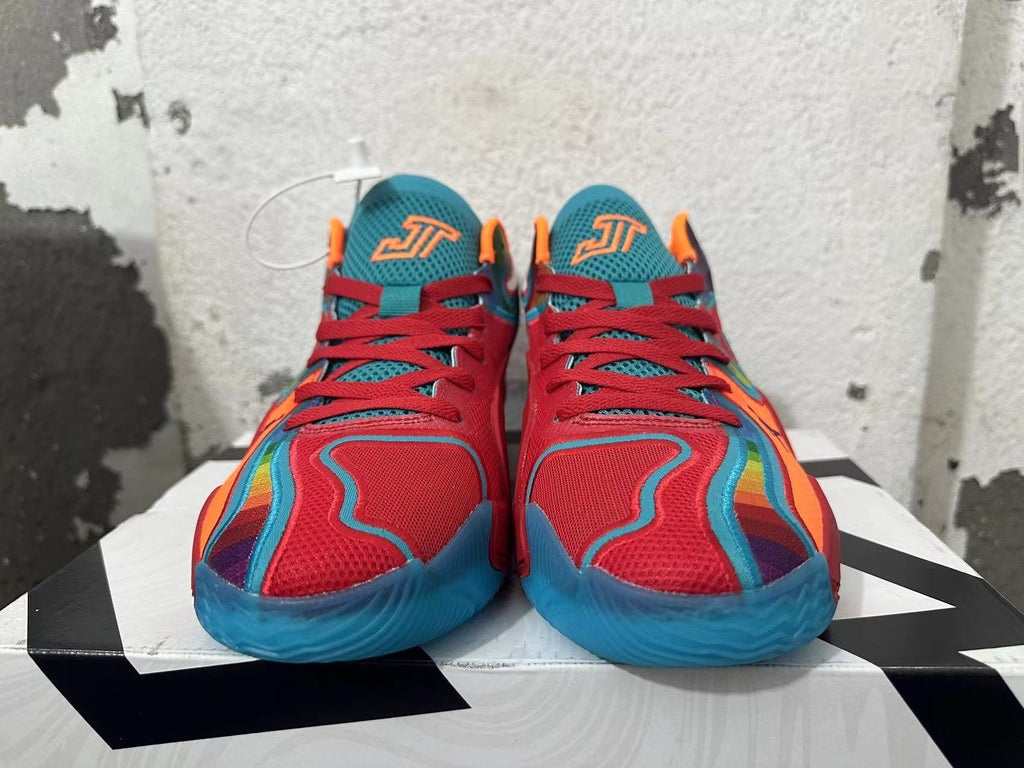 Front view of red Jordan basketball shoes with blue mesh tongues, orange accents and blue soles.